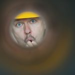 Man looking through a hole